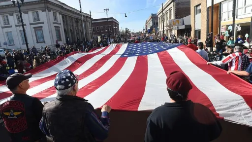 Participants holding up a large American Flag stretched out horizontally at the Linn County Oregon Veteran's Day Parade